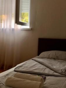 uma cama não feita com uma janela num quarto em Apartment Bregovi em Trebinje