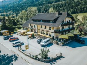 a large building with cars parked in a parking lot at Landgasthof Zum Hammerschmied in Ranten