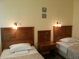 a bedroom with two beds and two lights on the wall at Sea View Family Hotel in Kranevo
