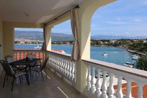 balkon ze stołem i krzesłami oraz widokiem na wodę w obiekcie Apartments in Silo - Insel Krk 13592 w mieście Šilo