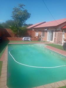 a swimming pool in front of a house at Tulo Bed and Breakfast in Kimberley