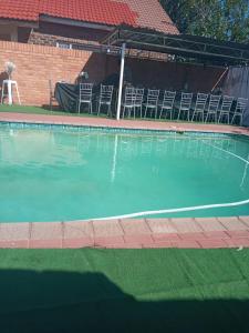 an empty swimming pool with chairs and a table at Tulo Bed and Breakfast in Kimberley