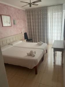 A bed or beds in a room at Hotel Alfonso