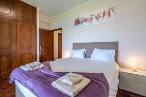 a bedroom with a large bed with two towels on it at Flowers island house 3 in Caniço