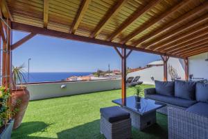 a patio with a blue couch and a table at Flowers island house 3 in Caniço