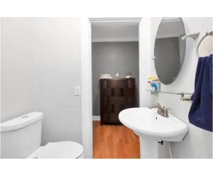 a white bathroom with a toilet and a sink at Cozy Downtown Studio by Toyota Center in Houston