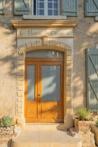 a wooden door of a building with a sign above it at La Maison de Beaumont in Beaumont-de-Pertuis
