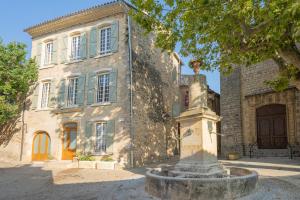 a large stone building with a fountain in front of it at La Maison de Beaumont in Beaumont-de-Pertuis