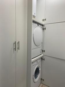a laundry room with white cabinets and a washing machine at Apartamentos BEACHYDAYS Montalvo in Torremolinos