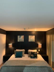 a bedroom with a large bed with two lamps at HOTEL SHOPPING VILA OLIMPIA in Sao Paulo