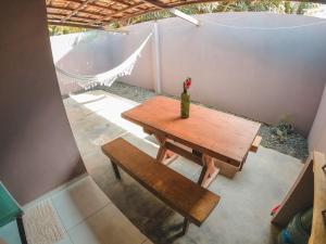 a wooden table and bench with a vase on it at Casa Toniatti 2 in Barra Grande +15 photos