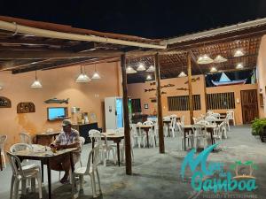 a man sitting at a table in a restaurant at Pousada Mar da Gamboa in Cairu