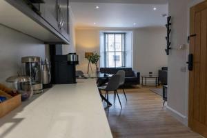 a living room with a kitchen and a dining room at Argyle Square Apartment in Oban