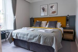 a bedroom with a large bed with towels on it at Argyle Square Apartment in Oban