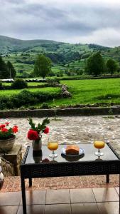 una mesa con dos copas de vino y un plato de comida en Casa Amalia - En el corazón verde de Cantabria!!, en Villacarriedo