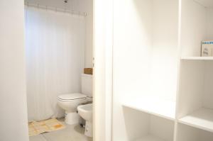 a white bathroom with a toilet and a window at Mono ambiente amplio, luminoso y moderno con excelente ubicación in Rafaela