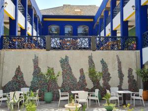 une fresque murale sur le côté d'un bâtiment avec des tables et des chaises dans l'établissement Hotel Batha, à Fès