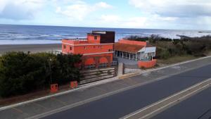 un edificio sul lato di una strada vicino all'oceano di Mutualidad de empleados del Club Gimnasia y Esgrima de Buenos Aires a Mar de Ajó