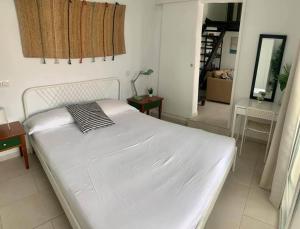 a white bed in a room with a mirror at The Perfect Stay Maspalomas in Maspalomas