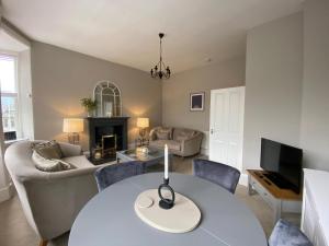 - un salon avec une table et un canapé dans l'établissement Lovely Entire Flat in Birnam, neighbouring Dunkeld, à Birnam
