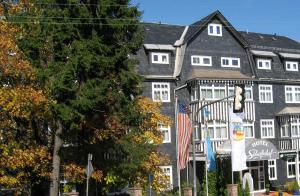 una casa grande con una bandera delante de ella en Boutique Hotel Schieferhof, en Neuhaus am Rennweg