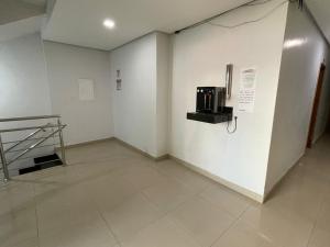 a room with a kitchen with a microwave on a wall at Hotel Oliveira 44 in Goiânia
