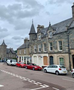 una fila de autos estacionados al lado de una calle en Lovely Entire Flat in Birnam, neighbouring Dunkeld, en Birnam