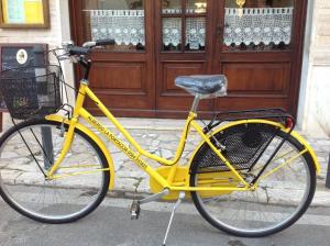 un vélo jaune garé devant un bâtiment dans l'établissement Albergo La Portaccia, à Castiglione della Pescaia
