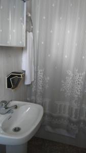 baño con lavabo y cortina de ducha en Pensión- Mari Loli - Oficial en Guardamar del Segura