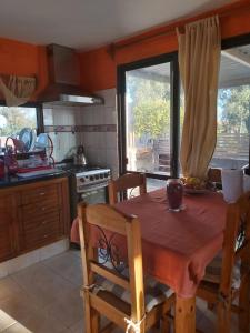 a kitchen with a wooden table and a dining room at Apart en playa hermosa piriapolis a dos cuadras de la playa in Piriápolis