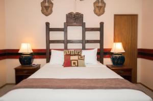 a bedroom with a large bed with two lamps at Lokahi Lodge in Volcano