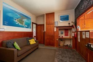 a living room with a couch and a map on the wall at Dolphin Lodge in Kaikoura