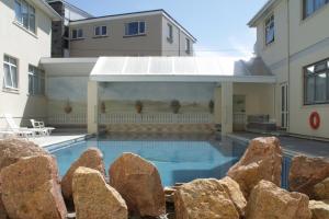 a swimming pool in the backyard of a house at Hotel Ambassadeur in St. Clements