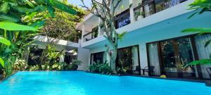 a swimming pool in front of a villa at The Pavilion Hotel Kuta in Kuta