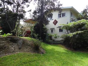 a house on a hill with a green yard at Volcano Hale in Volcano