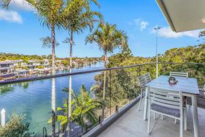 a balcony with a table and chairs and a view of a river at Serenity on Hastings Street, Noosa Heads in Noosa Heads