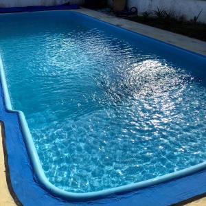 a swimming pool with blue water in it at Quarto Privado em residência no Coração de Foz - casa e banheiro compartilhado in Foz do Iguaçu