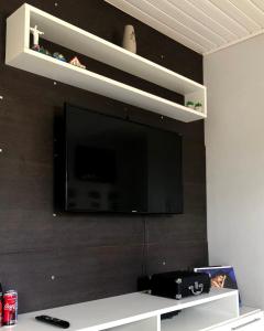 a flat screen tv hanging on a wall at Quarto Privado em residência no Coração de Foz - casa e banheiro compartilhado in Foz do Iguaçu