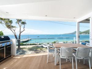 a dining room with a table and a view of the ocean at Shoal Bay Views in Shoal Bay