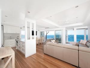 uma sala de estar branca com um sofá e uma cozinha em Shoal Bay Views em Shoal Bay