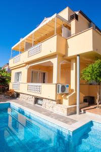 a house with a swimming pool in front of it at Pansion Tina in Šilo