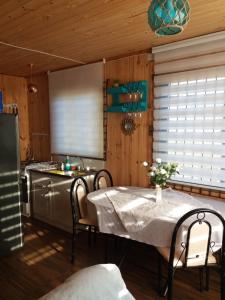 a kitchen with a table with chairs and a sink at Cabaña Sonido de Mar in Pichilemu