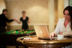 a woman sitting at a table with a laptop at Calverts Hotel - Newport, Isle of Wight in Newport