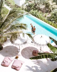 a man is jumping into a swimming pool at Autentik Penida "Glamping" - Adults only in Nusa Penida