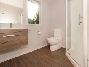 a bathroom with a toilet and a sink and a shower at Hosts on the Coast Belair Bach in Whitianga