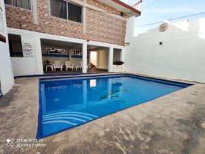 a swimming pool in front of a house at Hotel QP in Chachalacas
