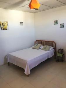 een slaapkamer met een bed in een witte kamer bij La Casa de Mike in Puerto Villamil