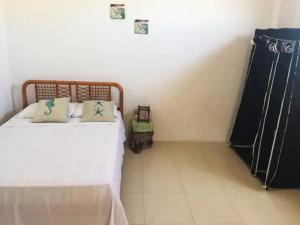 um pequeno quarto com uma cama e um quadro-negro em La Casa de Mike em Puerto Villamil