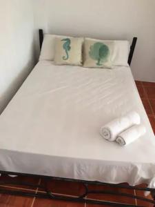 een bed met twee handdoeken en twee kussens erop bij La Casa de Mike in Puerto Villamil
