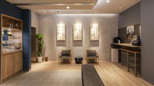 a waiting room with two chairs and paintings on the wall at Hotel Ohta in Ōzu